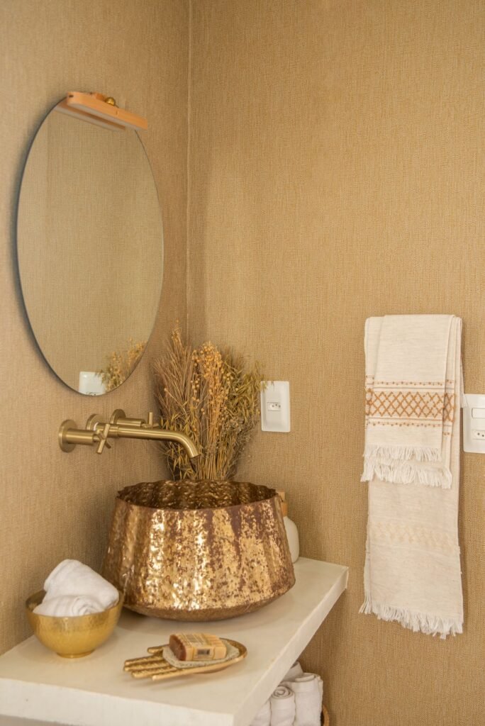 Bathroom with brass fixtures and round mirror
