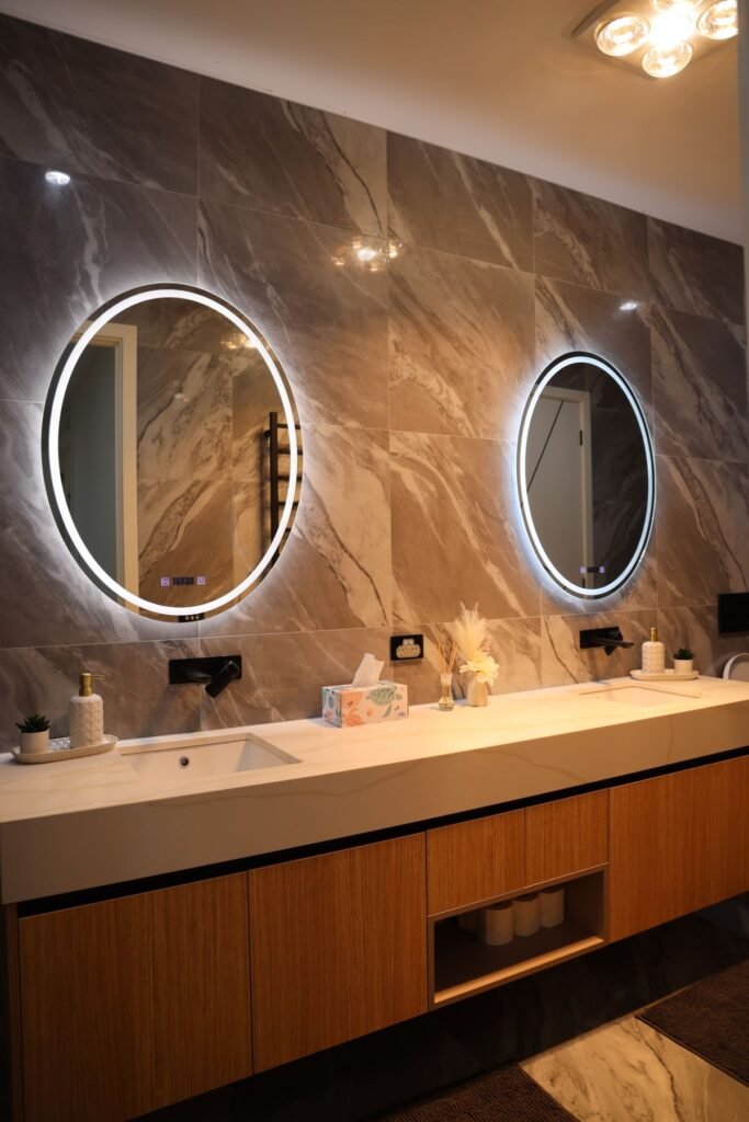Double vanity bathroom with backlit mirrors
