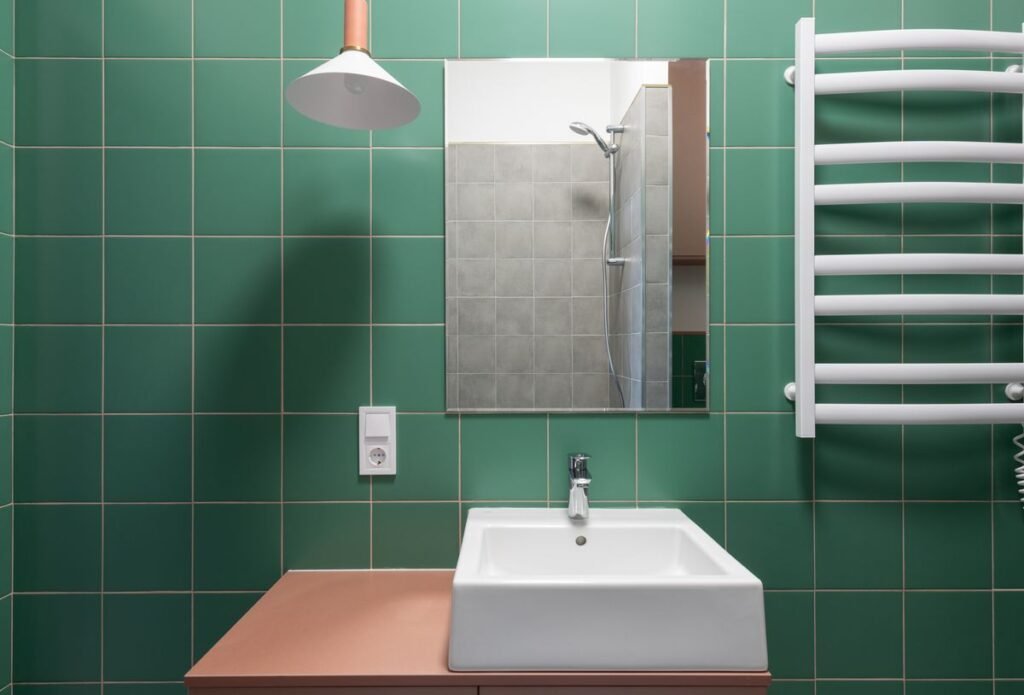 Bathroom with green tile and mirror