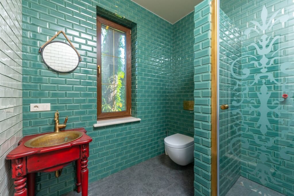 Bathroom with green tile and gold fixtures