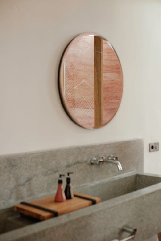 Minimalist bathroom with oval mirror and stone sink